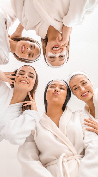 Happy young women in bathrobes, bottom view
